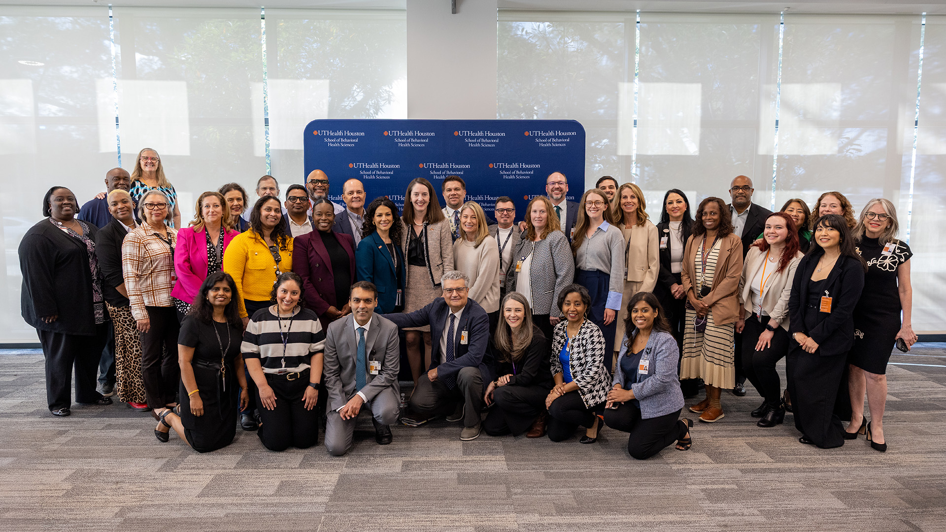 A big group of people posing for a photo at Dr. Kibbe's listening tour.